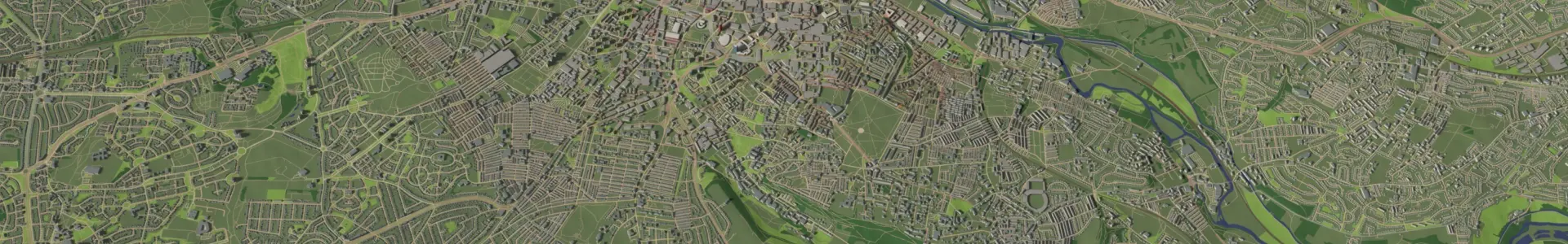 An aerial view of a town or city, displaying a network of roads, buildings, and green areas. The layout shows both urban development and surrounding natural landscapes, with rivers and parks visible.