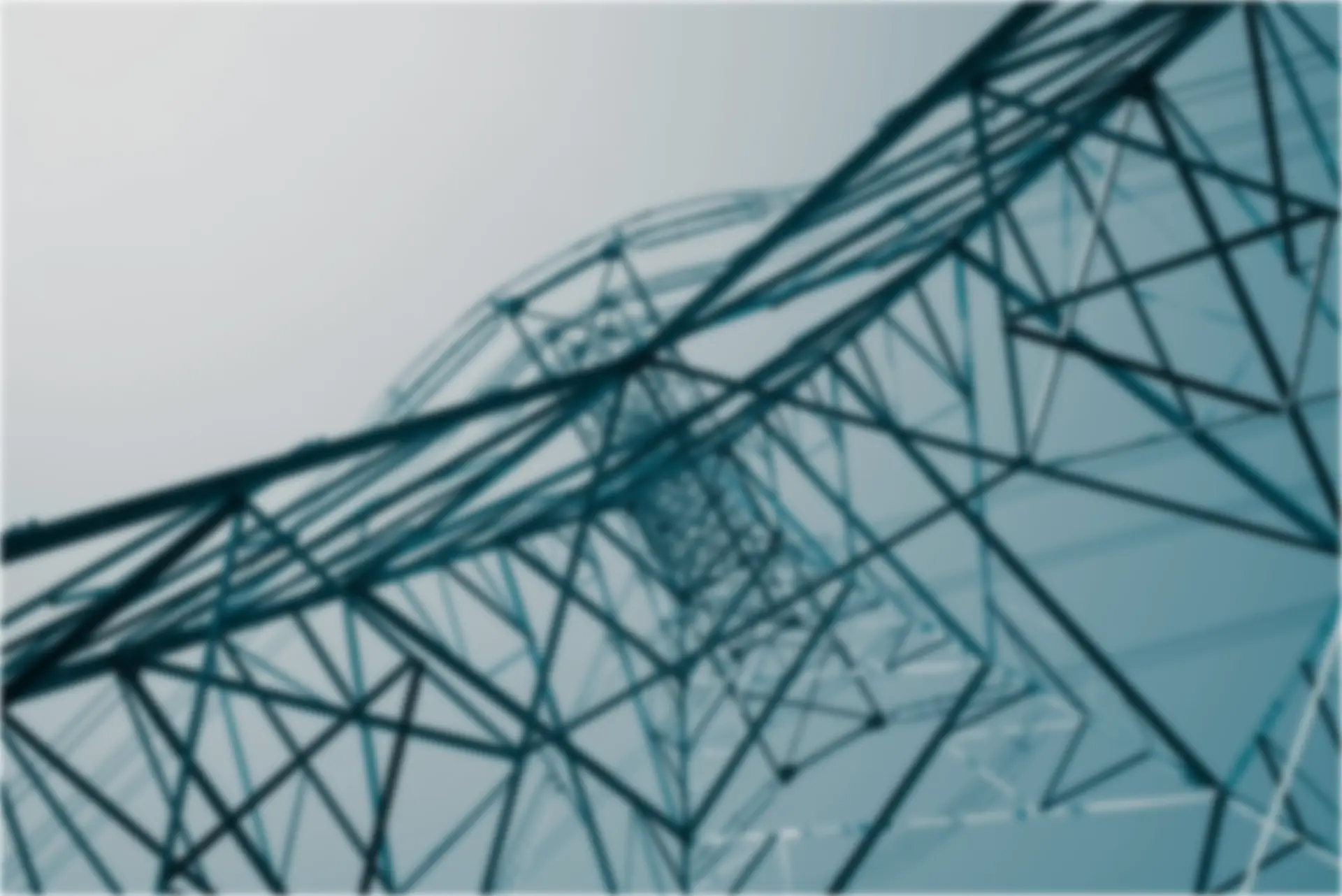 A low-angle view of a tall power transmission tower with a geometric structure against a soft gradient sky.