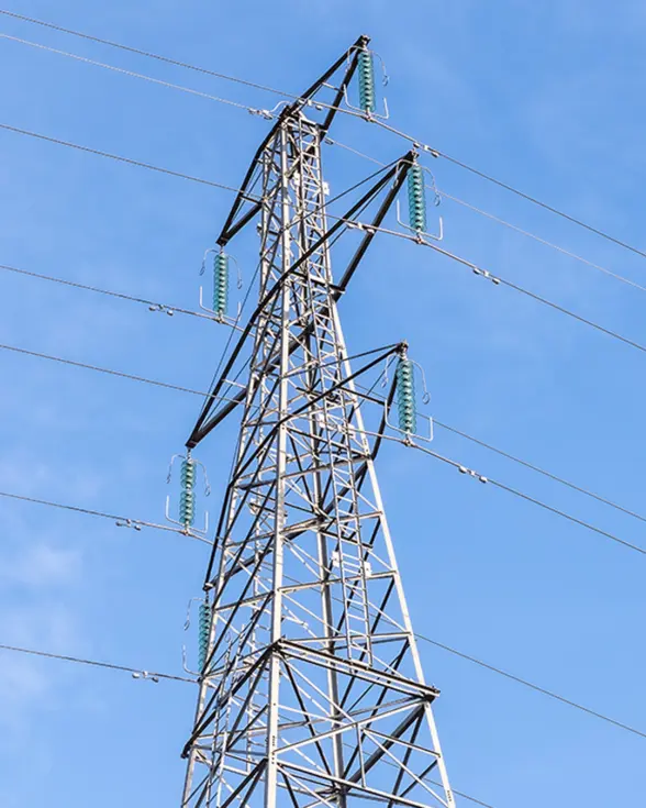 A tall metal power transmission tower against a clear blue sky, with several high-voltage lines connected to it.
