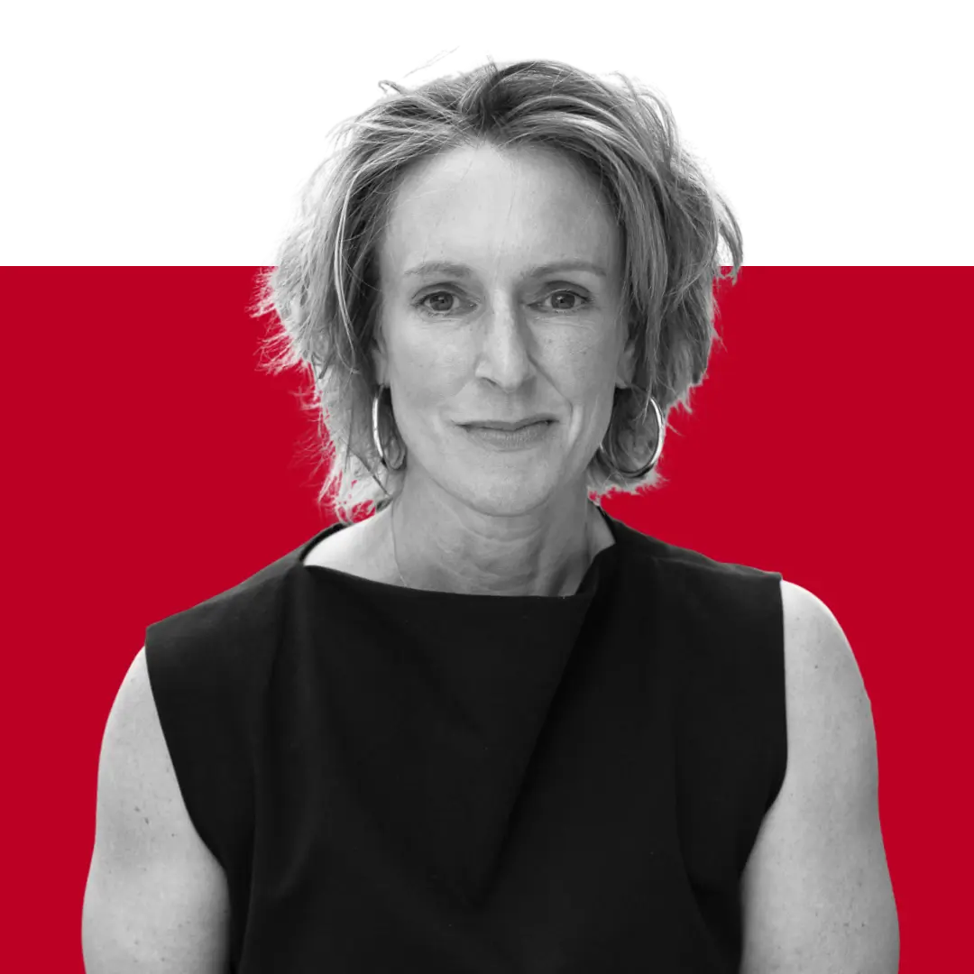 A woman with short, curly hair wearing a black sleeveless top, facing the camera with a neutral expression. The background is split with a solid red upper section.