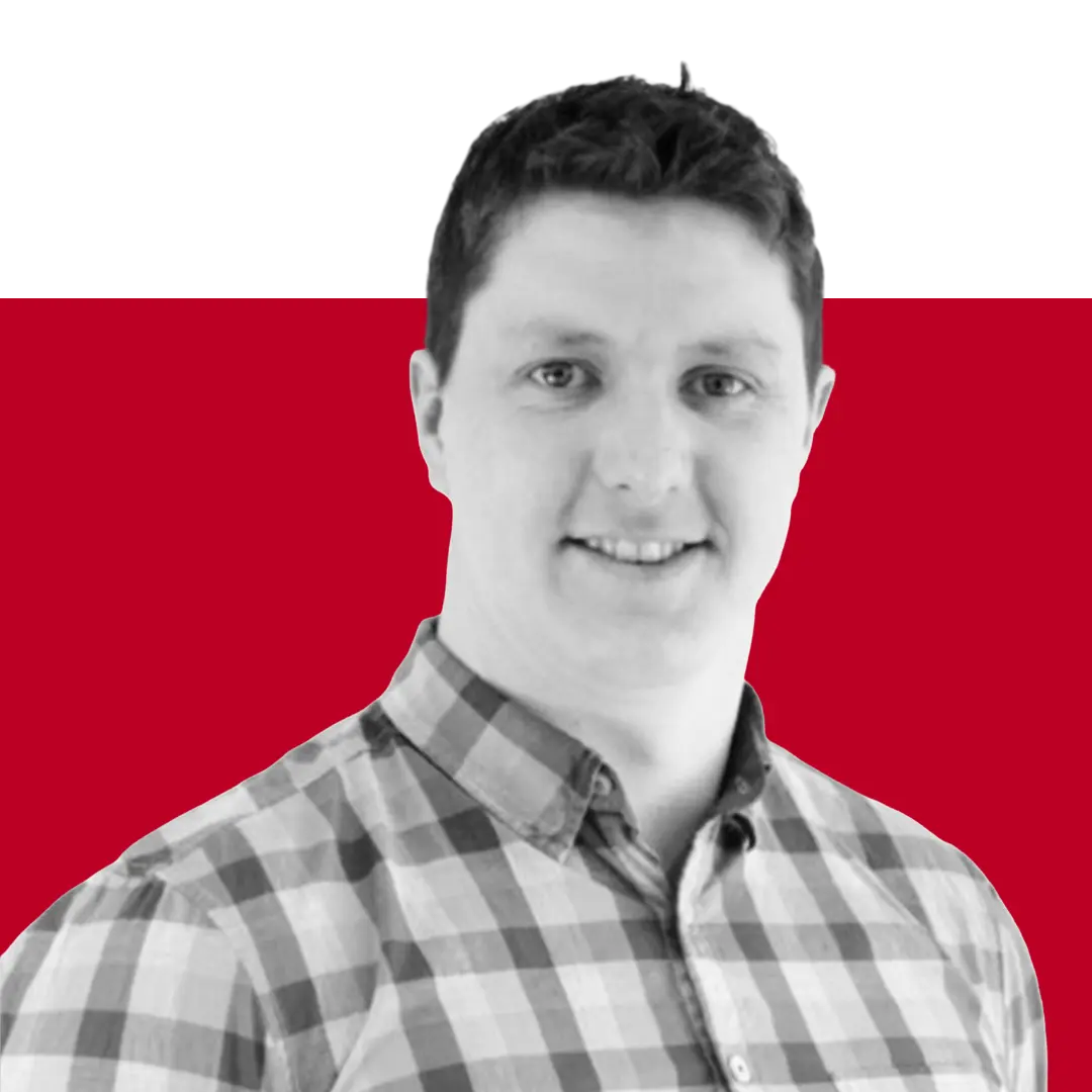 A person in a checked shirt smiling at the camera, set against a red and black background.