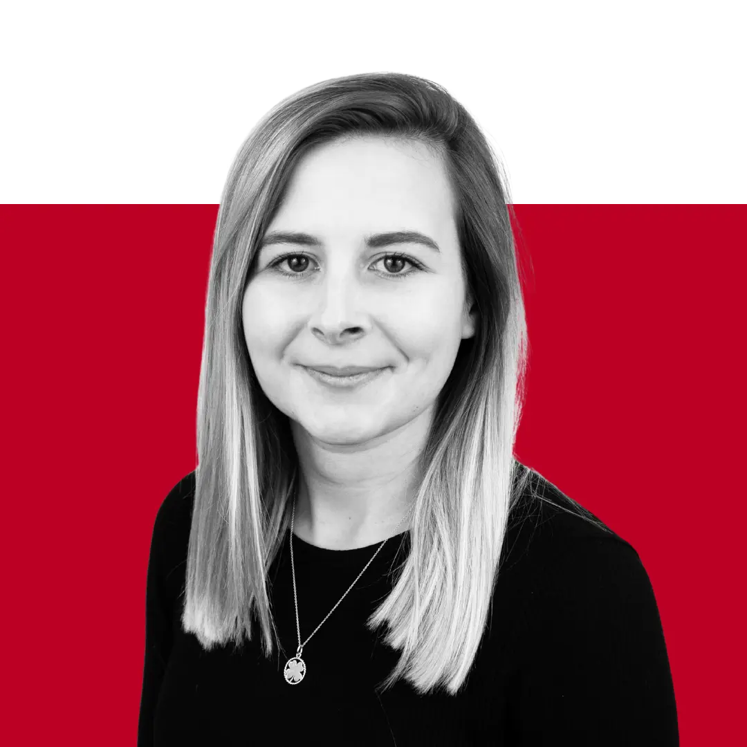 A portrait of a woman with shoulder-length blonde hair, wearing a black top and a necklace. The background features a gradient of red and black.