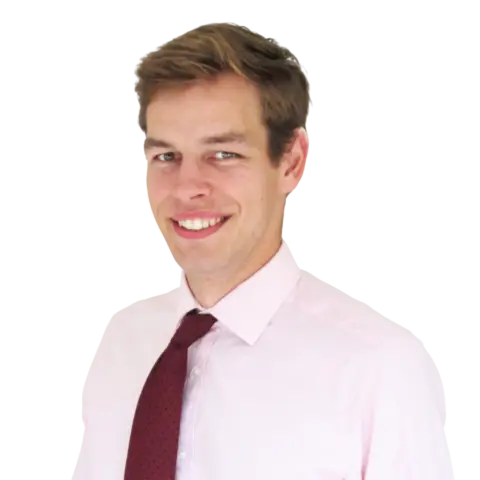 A man smiling while wearing a light pink dress shirt and a dark red tie, posed against a white background.