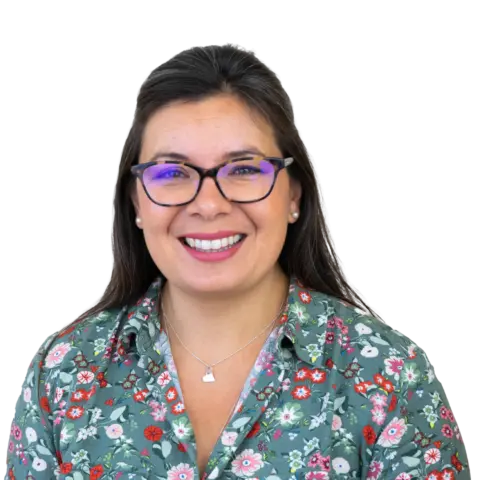 A woman with long dark hair wearing glasses and a floral-patterned shirt, smiling at the camera against a white background.
