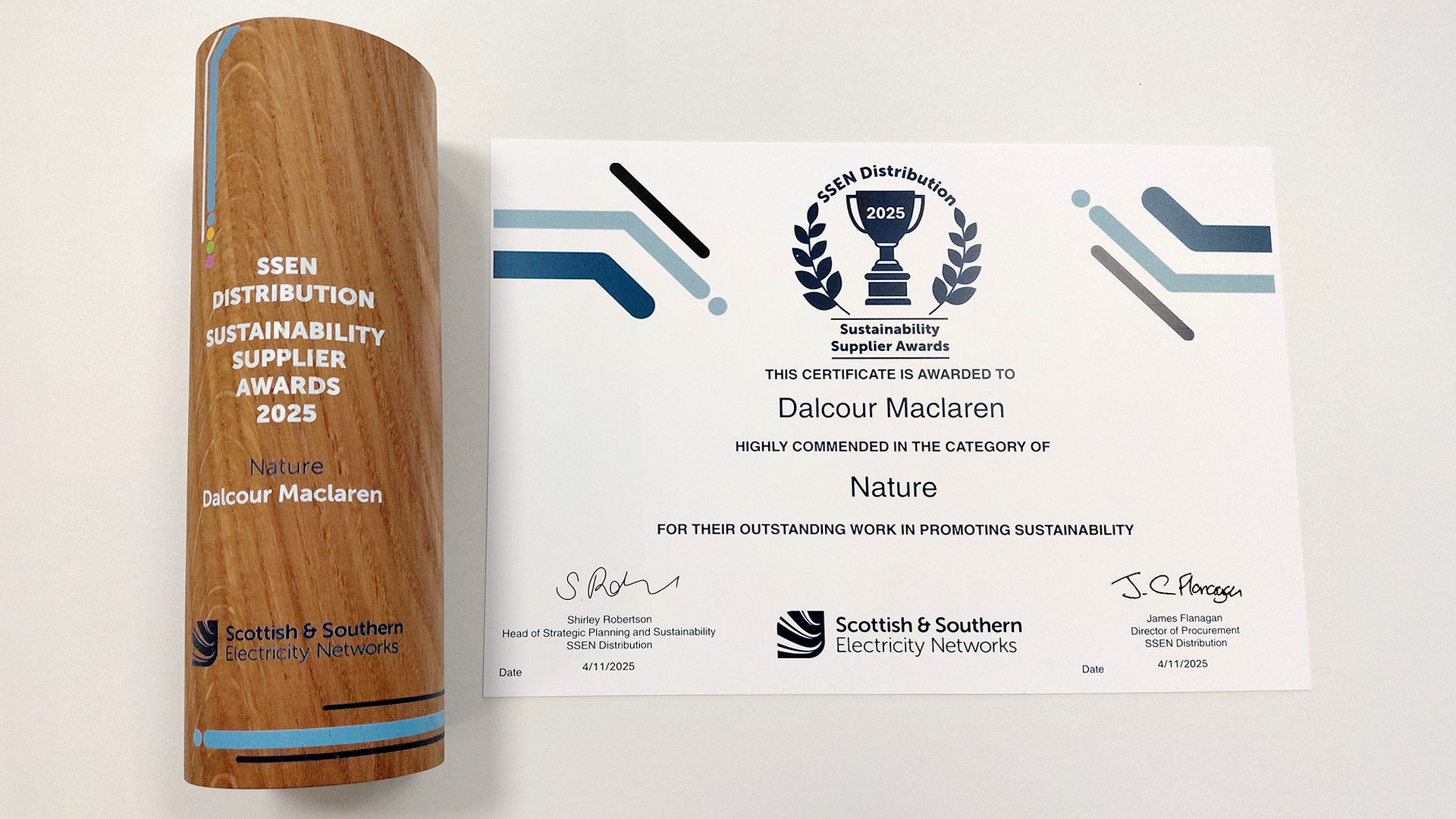 A wooden trophy next to a certificate awarded to Dalcour Maclaren for being highly commended in the category of Nature at the SSEN Distribution Sustainability Supplier Awards 2025.